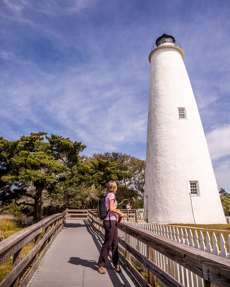 Lady looking up at a white Lighthouse