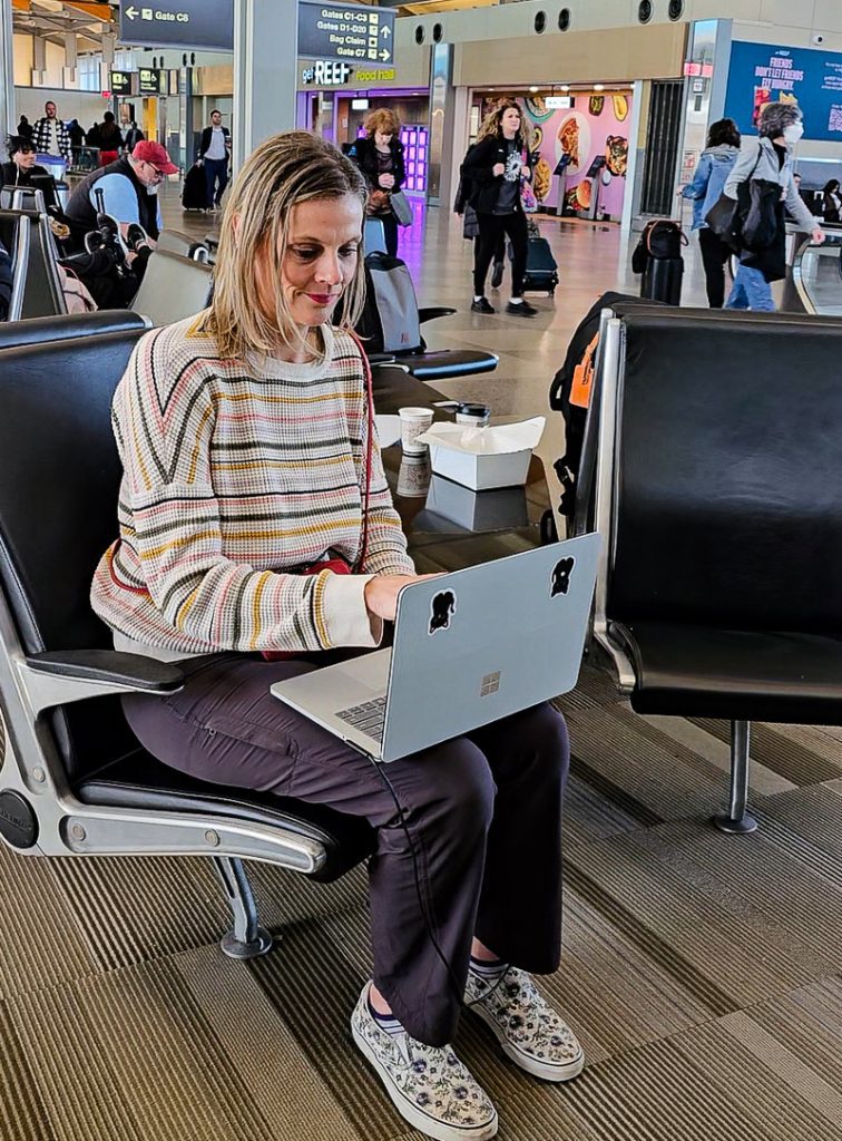 Lady working on a laptop in an airport