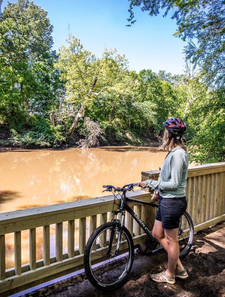 Woman and her bike overlooking a river