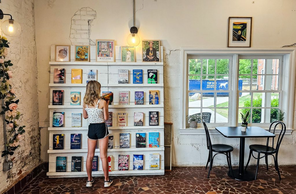 Girl looking at books inside a cafe