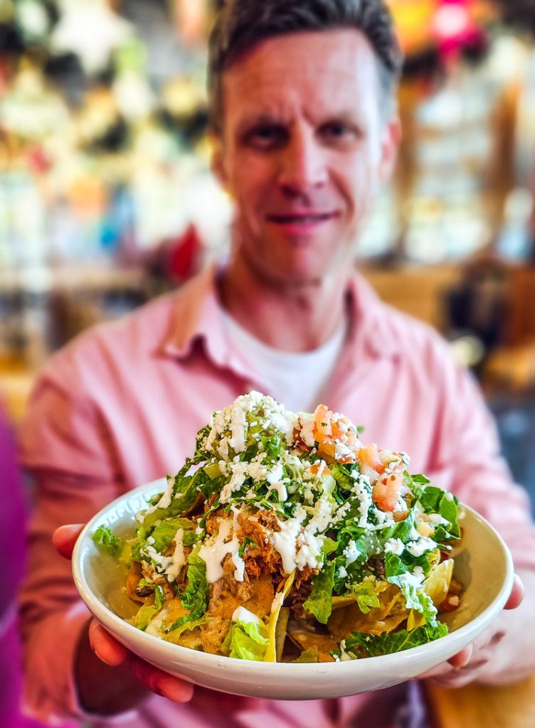 Man holding up a plate of Nachos