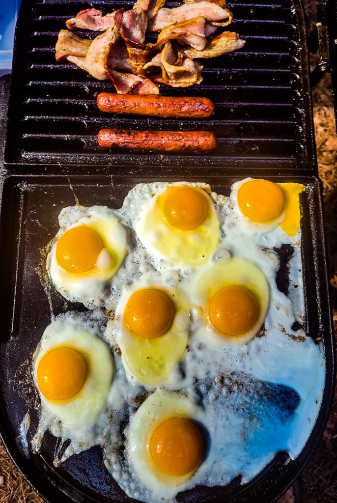 Eggs and sausages and bacon on a grill