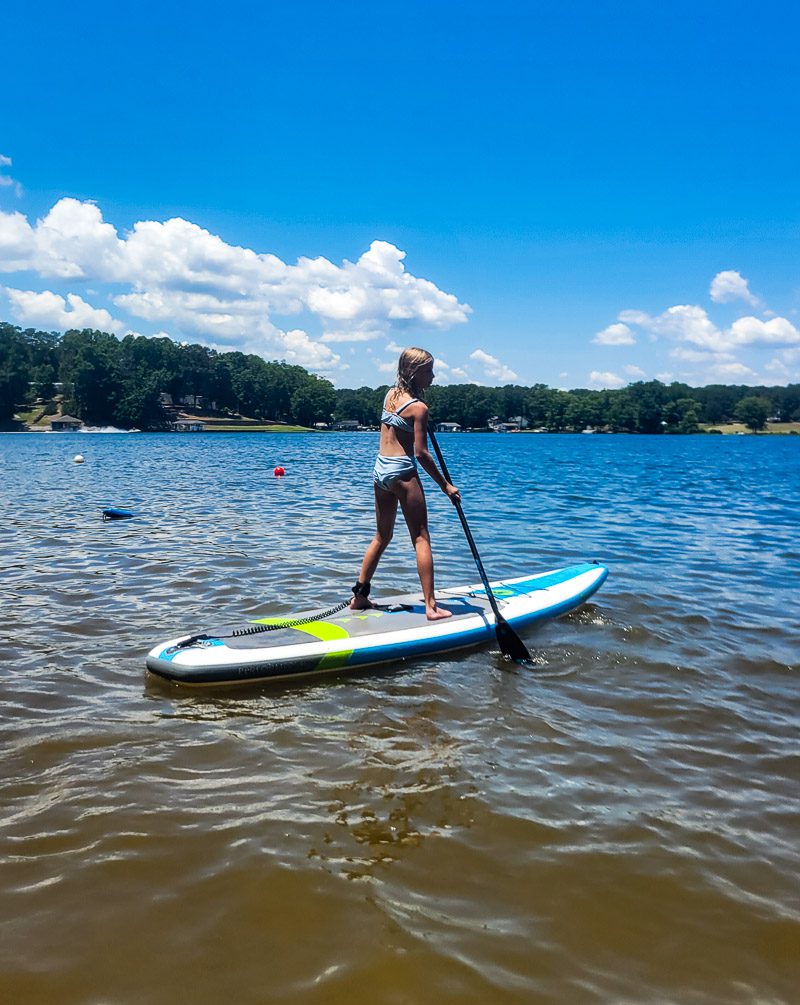 Young girl paddle boarding on a lake
