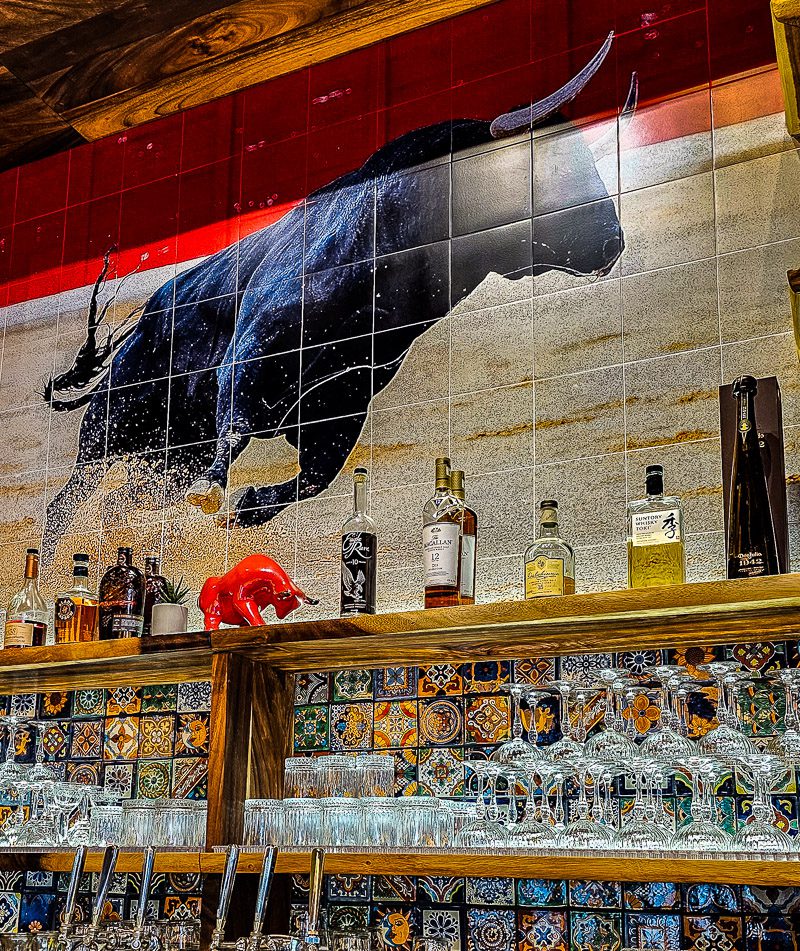 Painting of a bull behind a bar