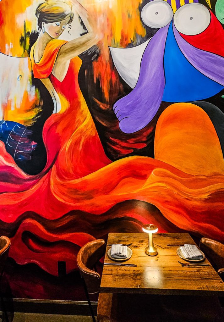 Table in a restaurant with a flamenco dancer mural on the wall