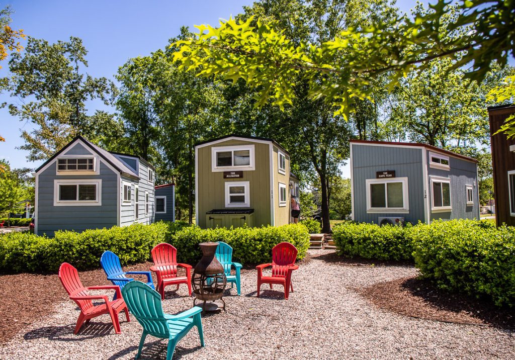 three tiny homes with a fire pit outside