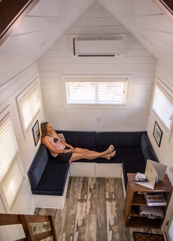 Woman sitting on a couch inside a tiny home