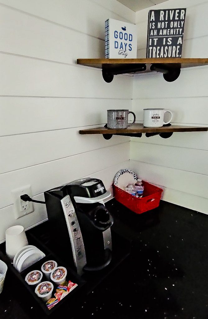 Coffee maker and shelves with cups in a kitchen