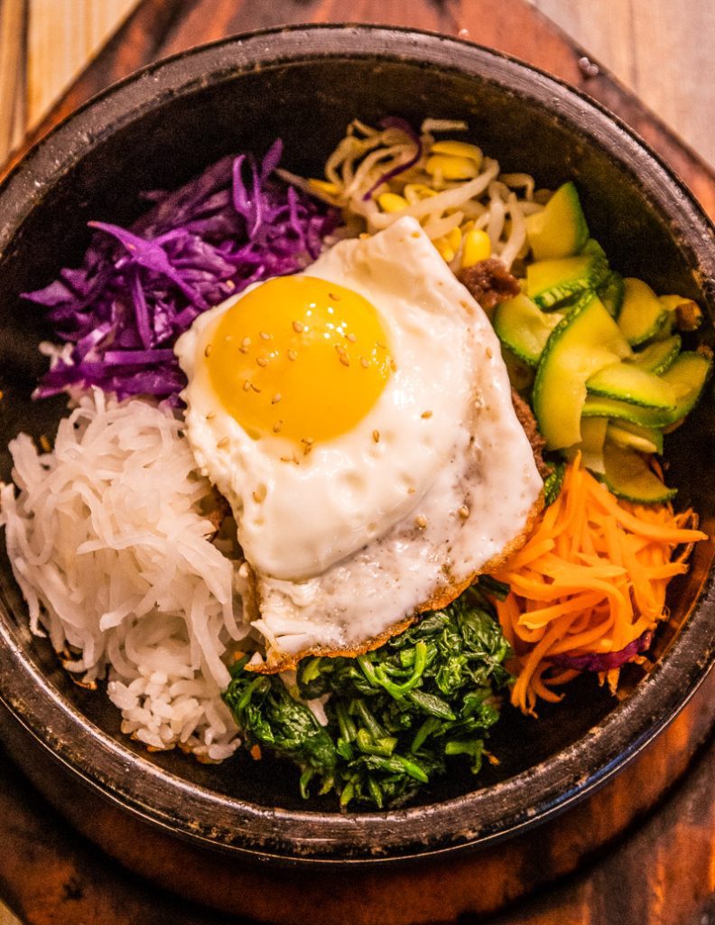 Bowl of mixed vegetables and a fried egg on top