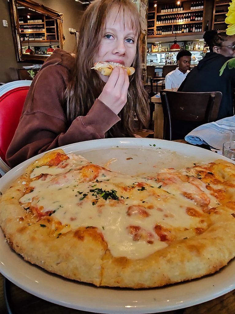 Kalyra Makepeace eating a cheese pizza