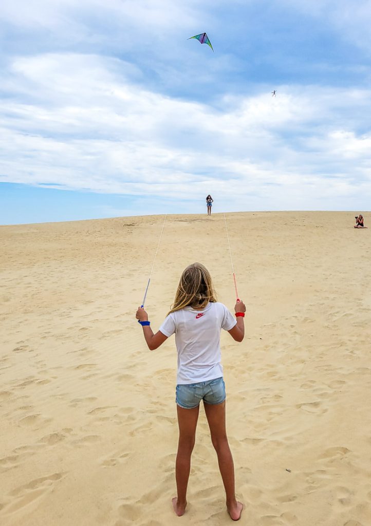 Savannah Makepeace flying a kite over sand dunes in Jockey's Ridge, Outer Banks