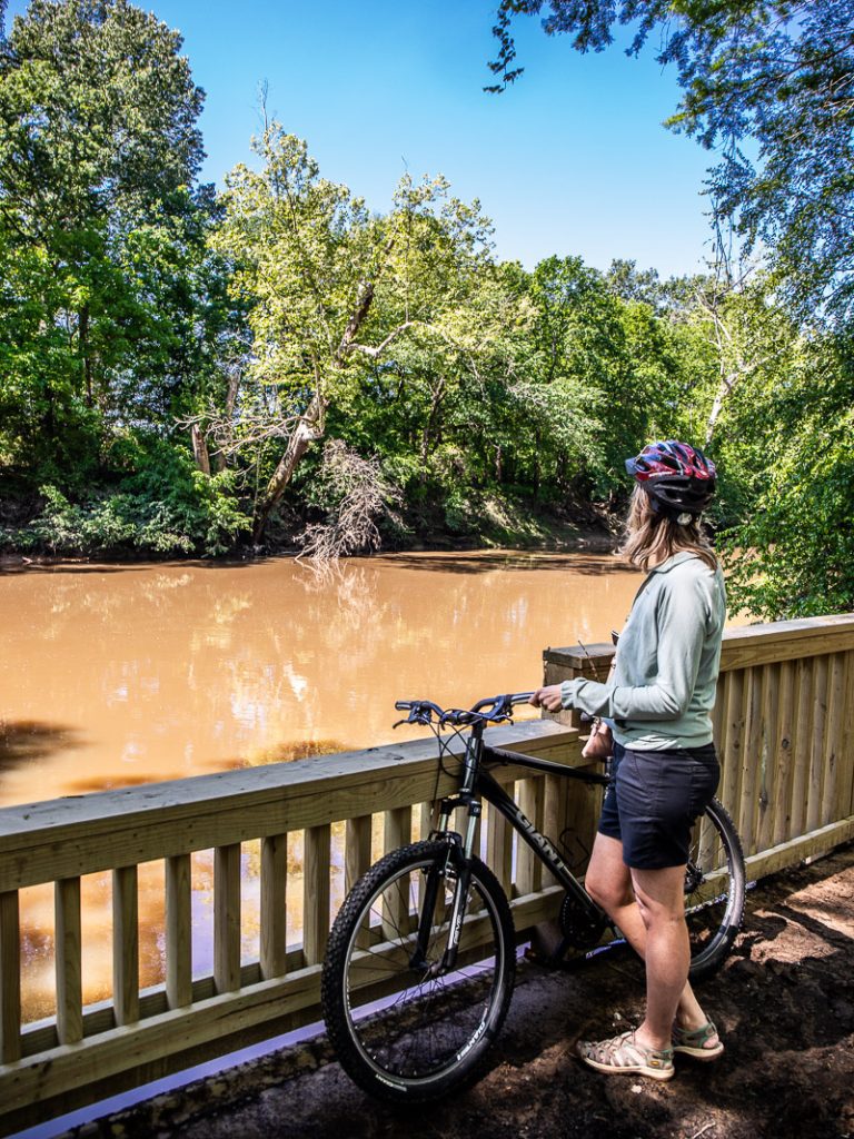 Lady with a bike overlooking the river