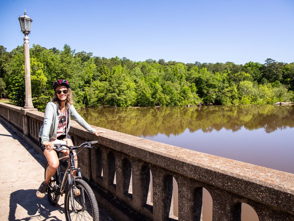 Lady on a bike overlooking a river