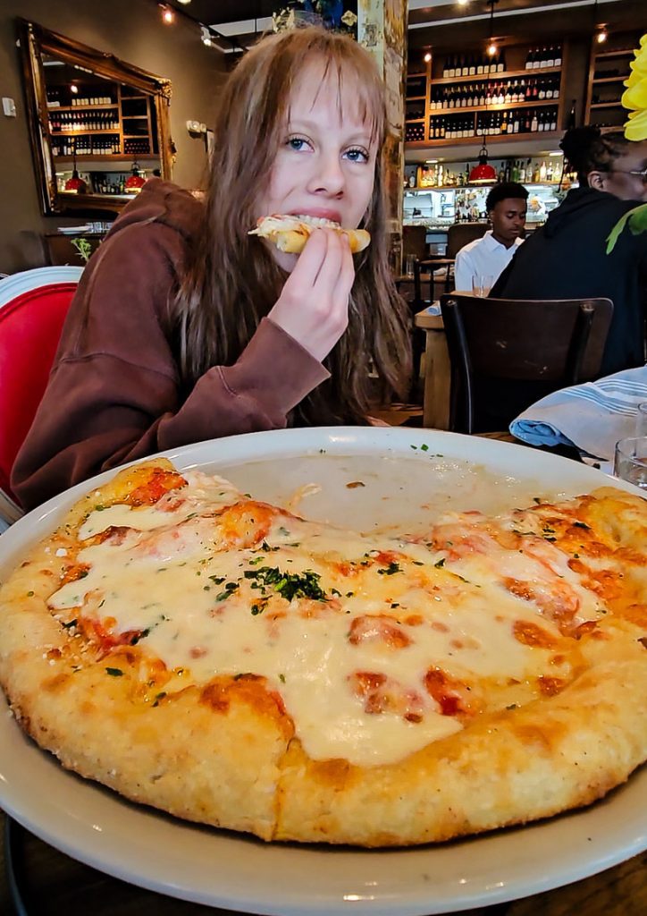 Young girl eating a cheese pizza