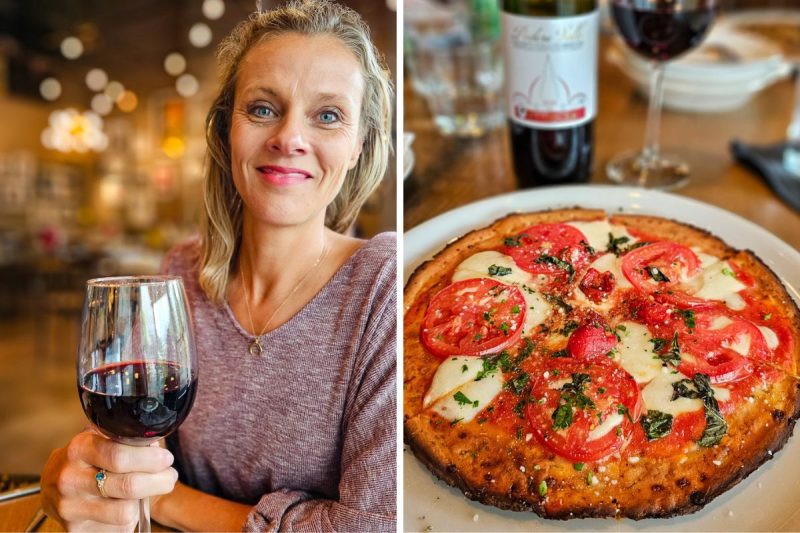 Lady drinking a glass of red wine with a pizza