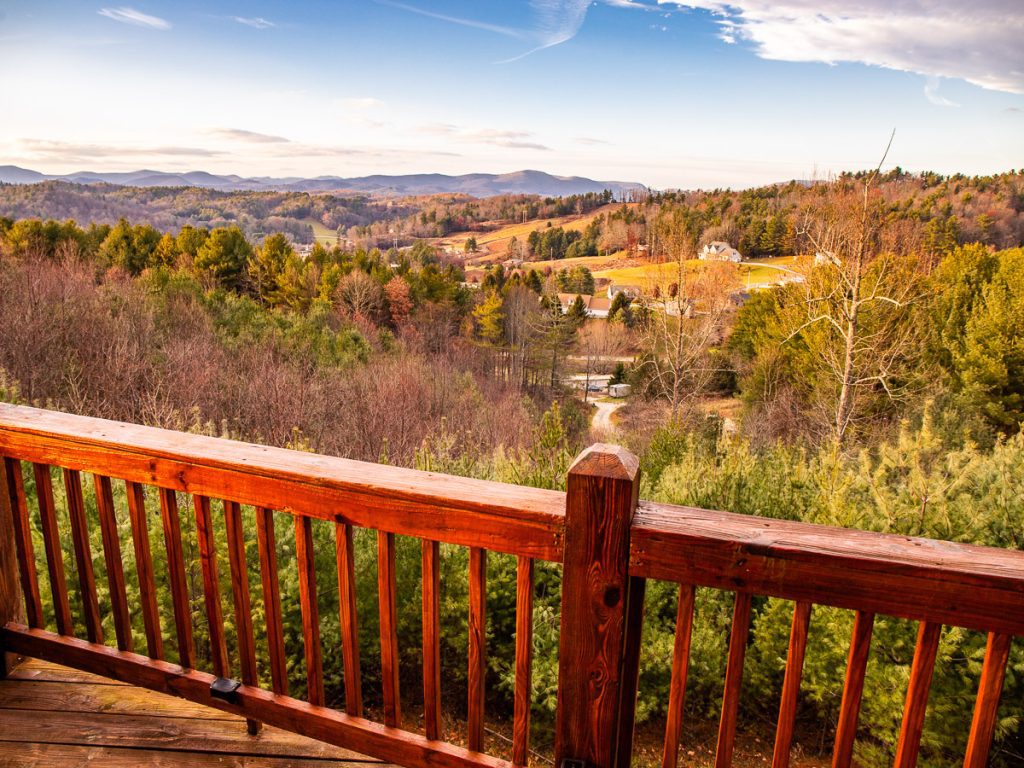 View of the mountains from a deck of a log cabin