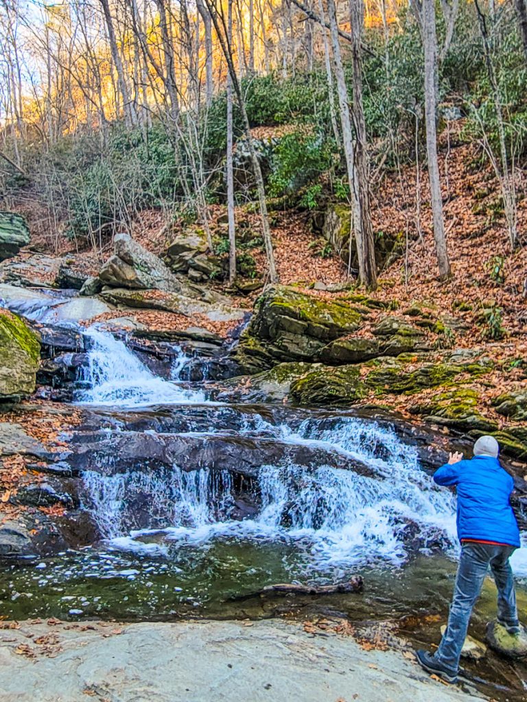 Man taking a photo of a waterfall.