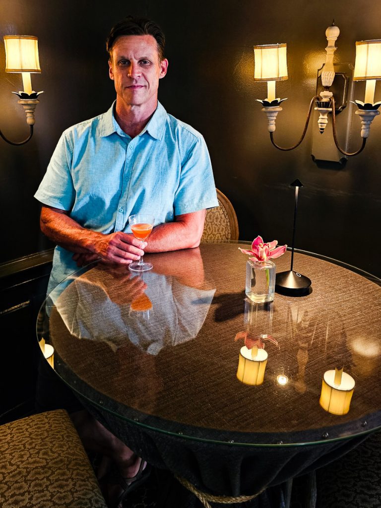 Man standing at a table with a cocktail