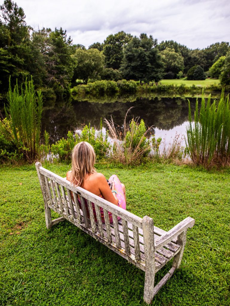 Lady sitting on a chair overlooking a pond