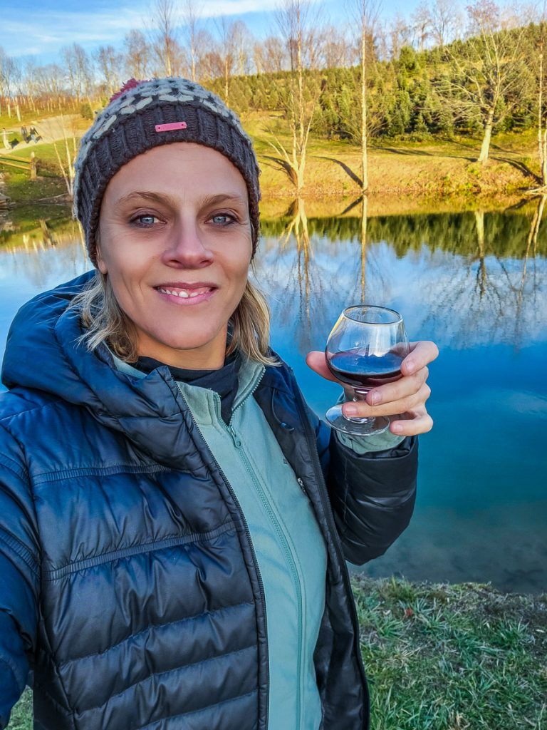 Lady drinking wine with view of a pond