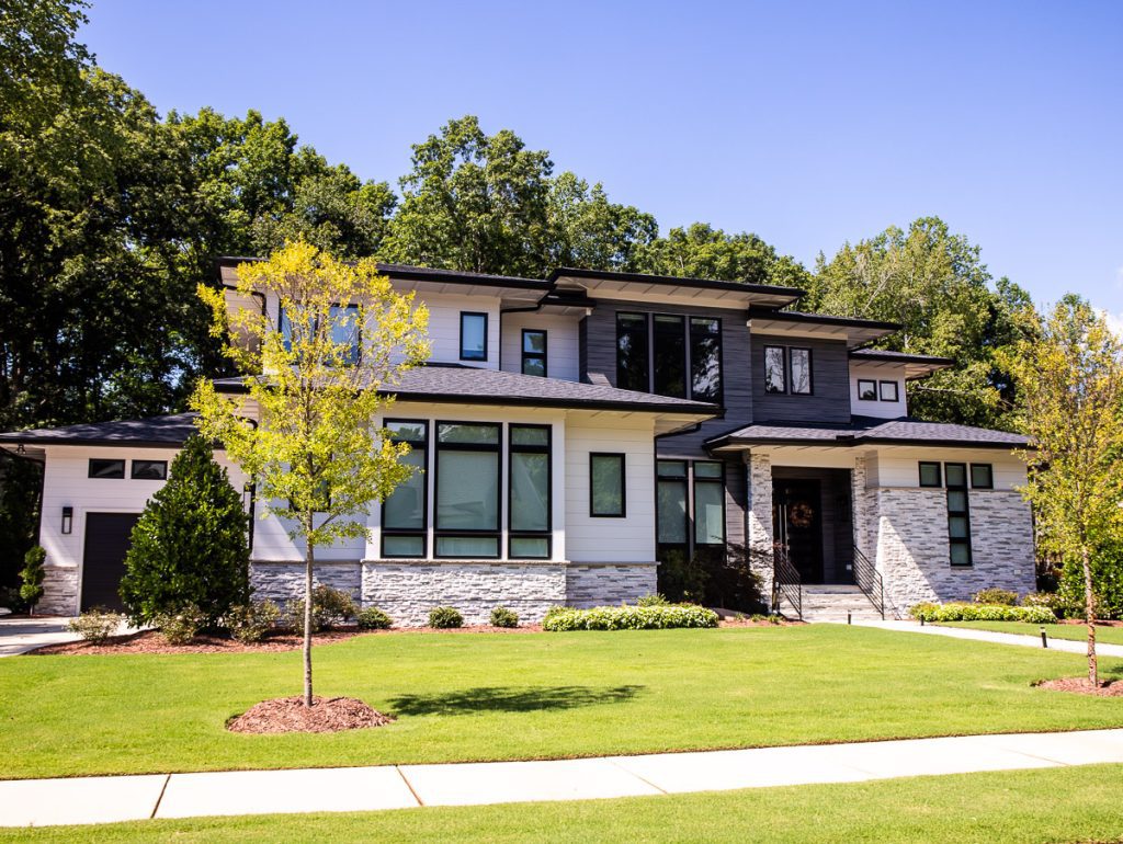 Two story home with green grass and trees