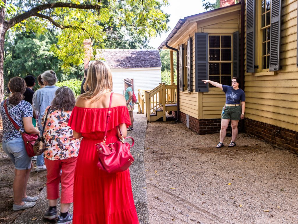 People standing outside a yellow house on a walking tour
