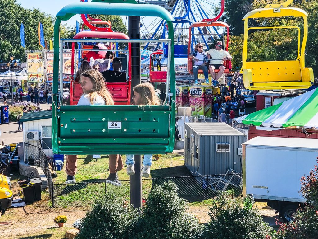 Kids riding a chair lift at a festival
