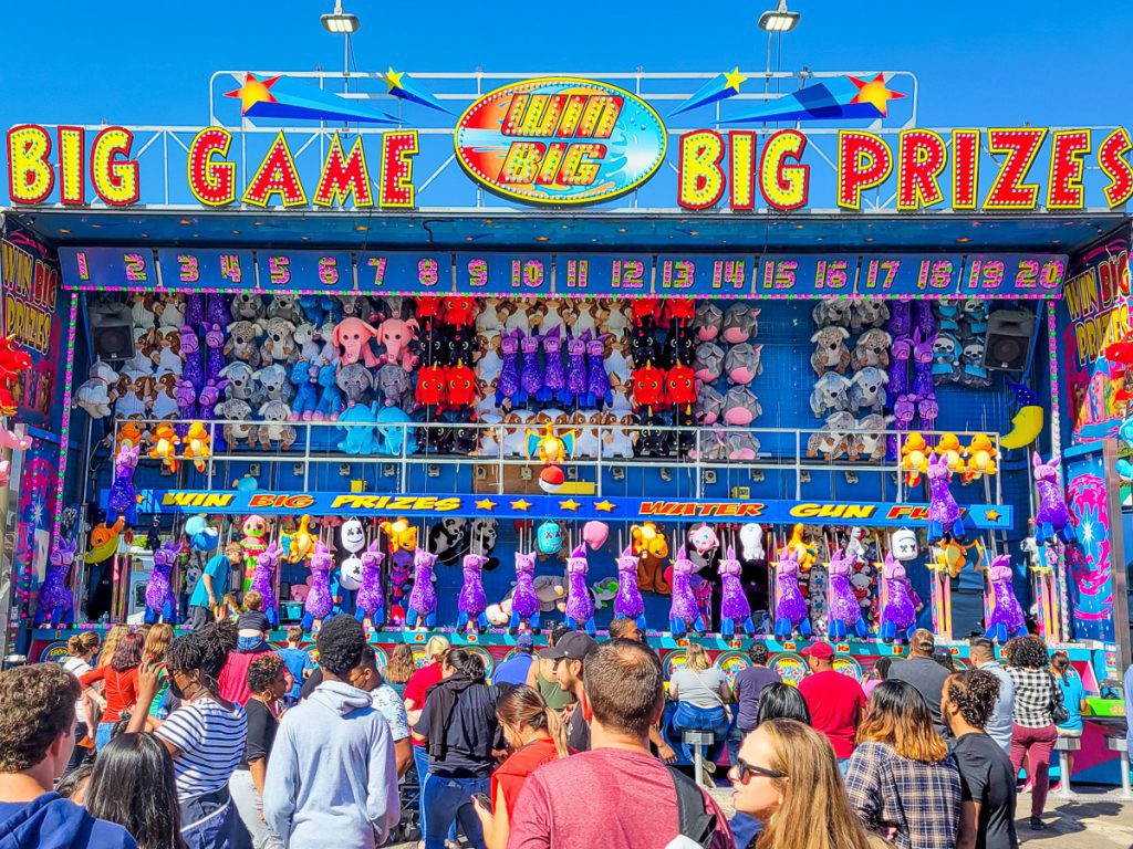People in front of a game at a state fair