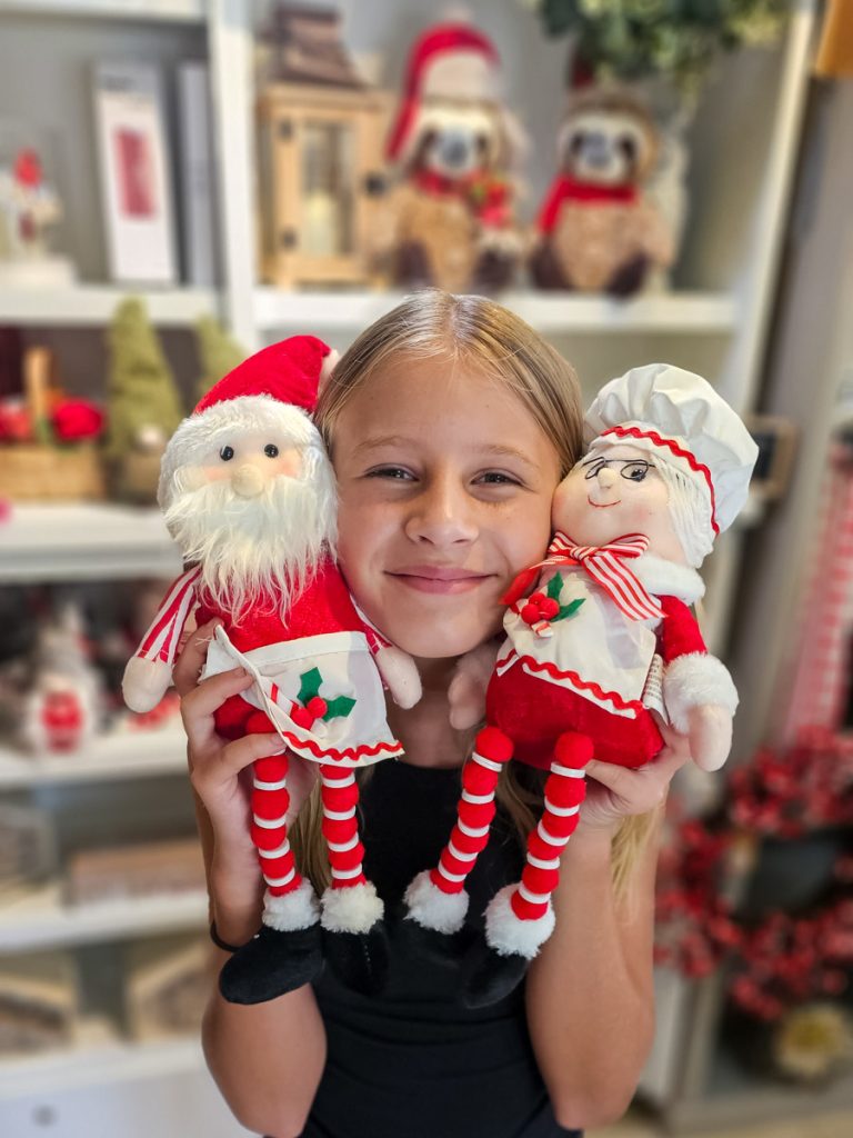 savannah holding stuffed mr and mrs Claus dolls to her face