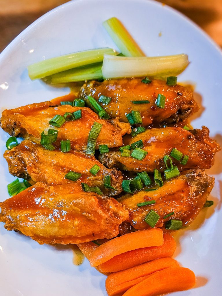 Plate of chicken wings, carrots and celery.