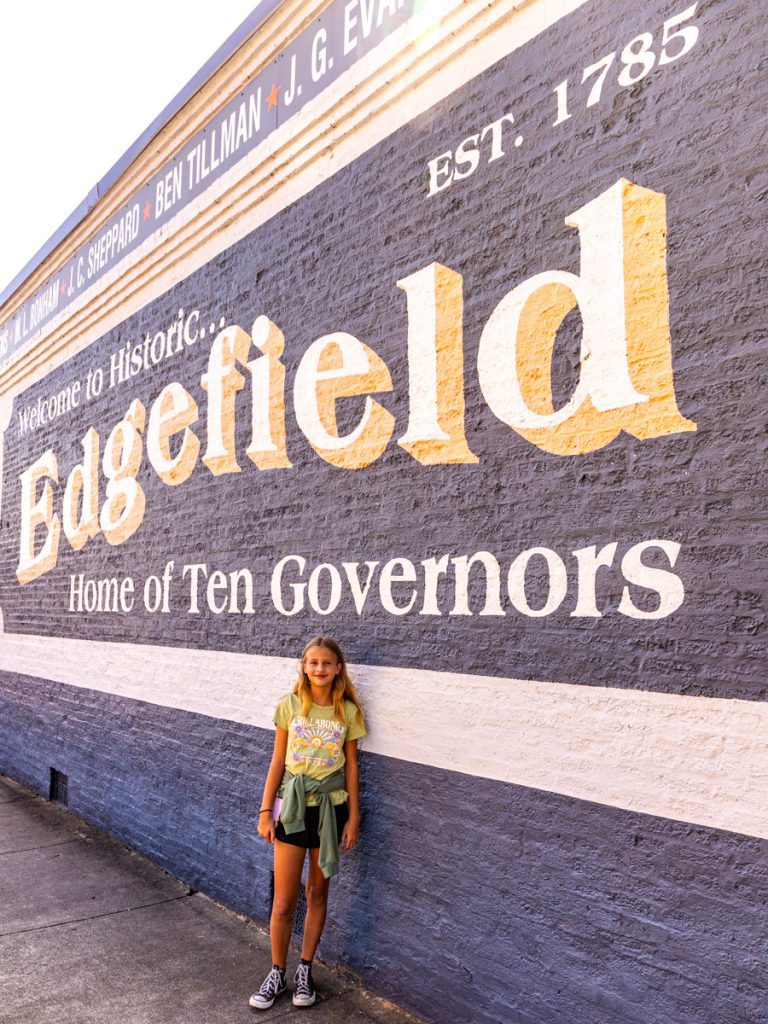 savannah standing in front of edgefield mural