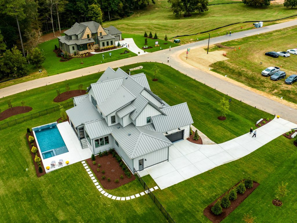 Aerial photo of houses in a neighborhood with a swimming pool.