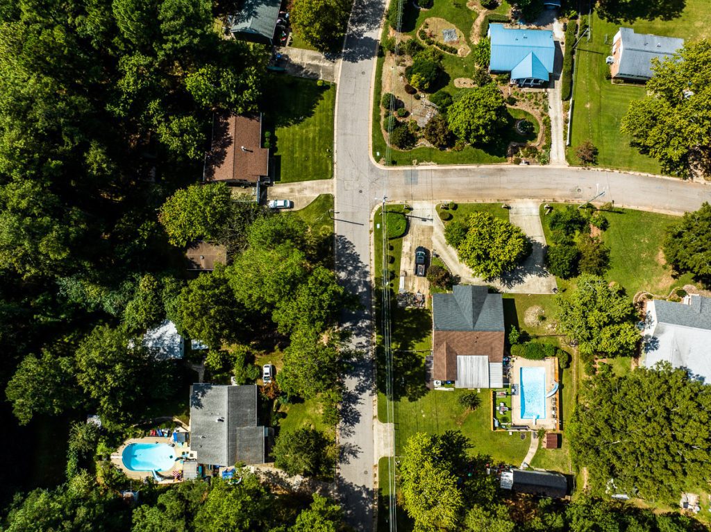 Aerial photo of houses in a neighborhood with green trees.