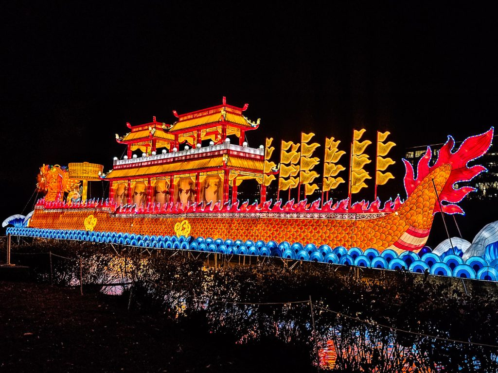 Illuminated dragon boat on the water.