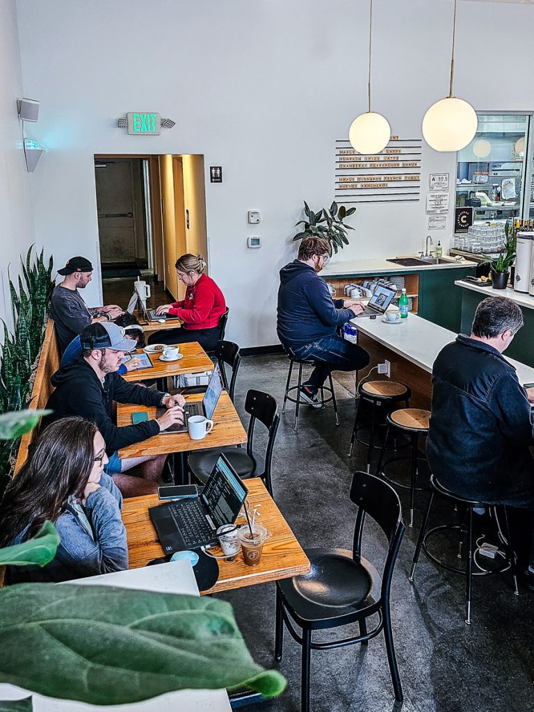 People sitting in a cafe working on their computers.